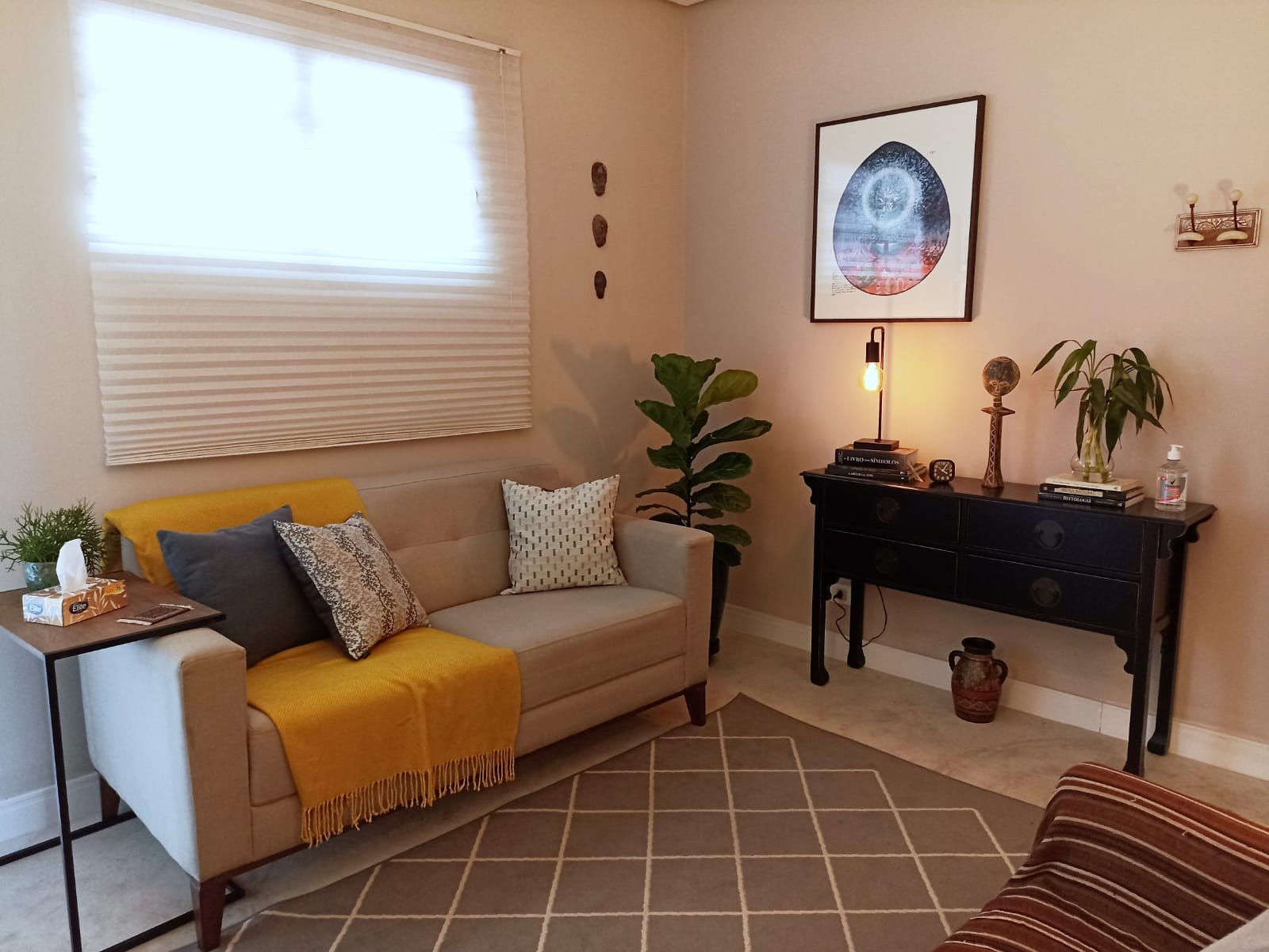 Sala de atendimento com sofá e manta amarela