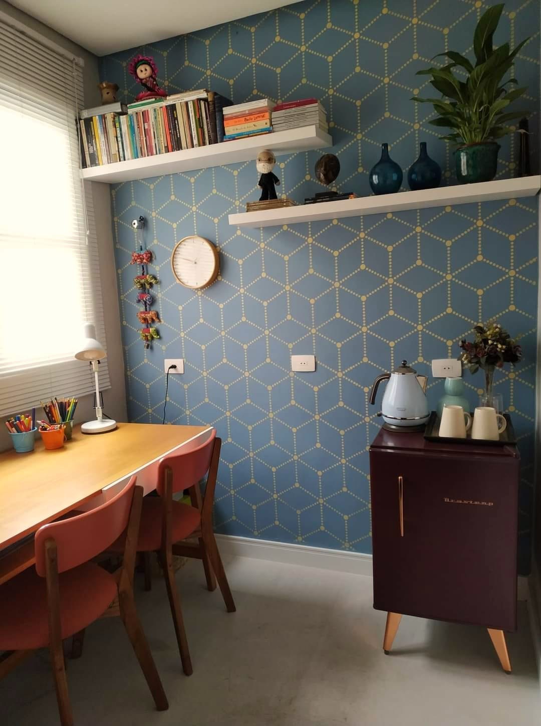 Sala com parede azul geométrica e mesa